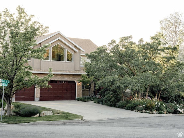 9788 S Dante Rd E, Sandy, UT 84092 - view of front of house featuring an attached garage, driveway, and brick siding