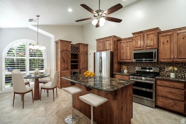 3524 S Price Hills Dr, St George, UT 84790 - kitchen with stainless steel appliances, tasteful backsplash, ceiling fan, high vaulted ceiling, and a kitchen bar