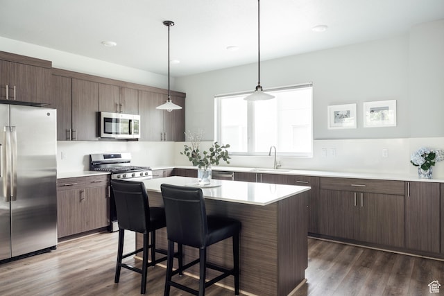 736 S 300 E Unit 1A, Salt Lake City, UT 84111 - kitchen with stainless steel appliances, a kitchen bar, light countertops, and dark wood-type flooring