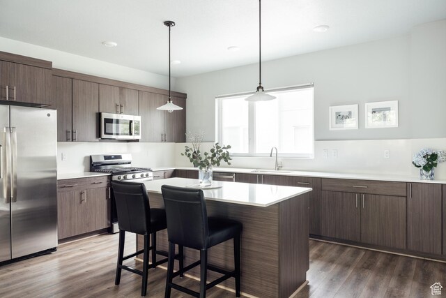 736 S 300 E Unit 1A, Salt Lake City, UT 84111 - kitchen with stainless steel appliances, a kitchen bar, light countertops, and dark wood-type flooring