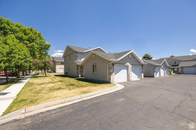 162 W 1275 S Unit 162, Logan, UT 84321 - view of front of property with a garage, a front yard, stucco siding, and asphalt driveway