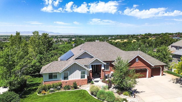 1269 Alice Ln, Farmington, UT 84025 - view of front of home featuring brick siding, board and batten siding, a garage, driveway, and a front lawn