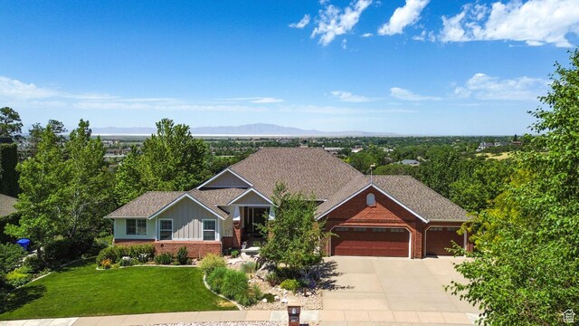 1269 Alice Ln, Farmington, UT 84025 - view of front of house featuring brick siding, a garage, concrete driveway, a front lawn, and board and batten siding
