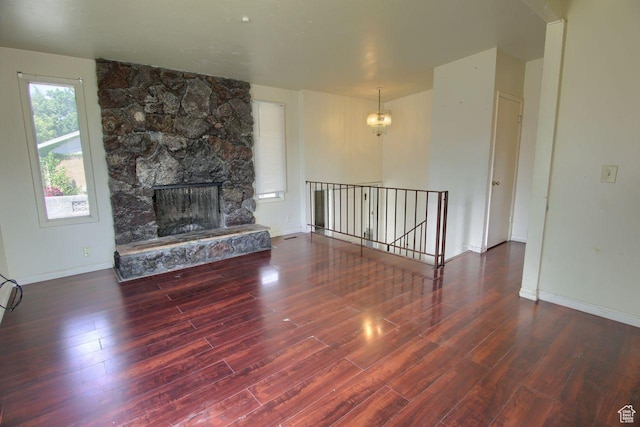 2266 W Arches Dr, Taylorsville, UT 84129 - unfurnished living room with a chandelier, wood finished floors, and a stone fireplace