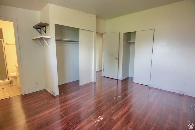 2266 W Arches Dr, Taylorsville, UT 84129 - unfurnished bedroom with wood finished floors, two closets, and ensuite bathroom