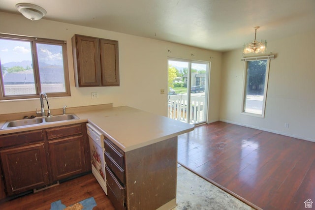 2266 W Arches Dr, Taylorsville, UT 84129 - kitchen with a peninsula, dark wood-style flooring, light countertops, and a chandelier