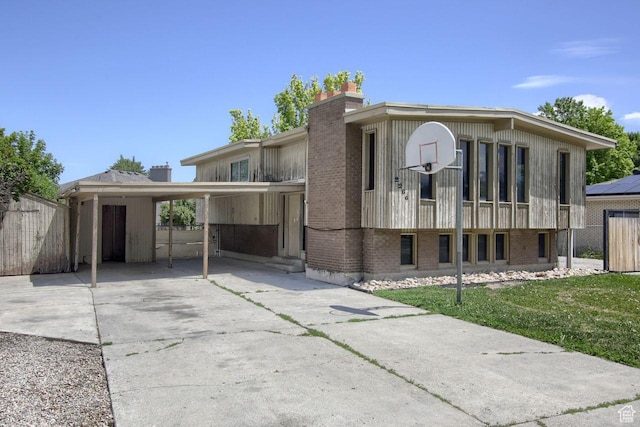 2266 W Arches Dr, Taylorsville, UT 84129 - view of front facade featuring concrete driveway, a chimney, brick siding, and an attached carport