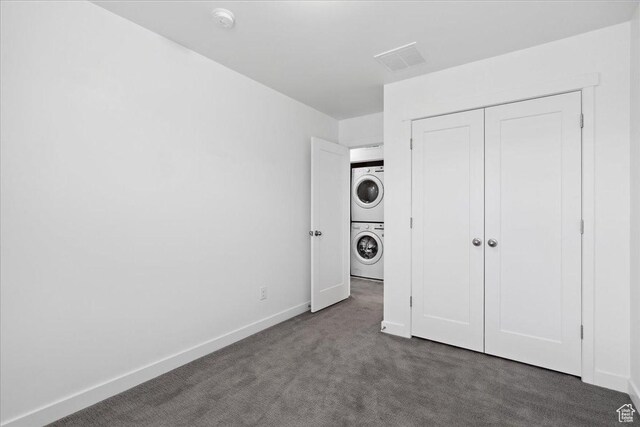 5504 W Burntside Ave, South Jordan, UT 84009 - unfurnished bedroom featuring stacked washer and clothes dryer, dark carpet, and a closet