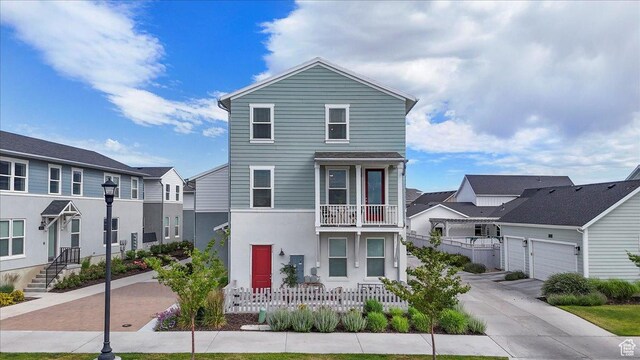 5504 W Burntside Ave, South Jordan, UT 84009 - townhome / multi-family property with a balcony, a residential view, stucco siding, concrete driveway, and a garage
