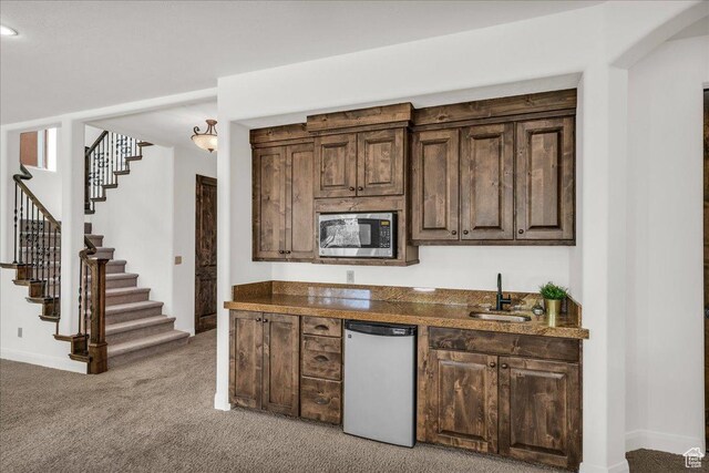 1683 W Red Cloud Dr, St George, UT 84770 - kitchen featuring dishwasher, stainless steel microwave, light colored carpet, and dark brown cabinetry