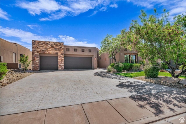 1683 W Red Cloud Dr, St George, UT 84770 - pueblo revival-style home with a garage, concrete driveway, stucco siding, and stone siding
