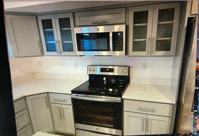 123 E 460 N, Vineyard, UT 84059 - kitchen with appliances with stainless steel finishes, light countertops, glass insert cabinets, and gray cabinetry