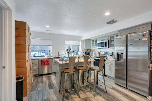 123 E 460 N, Vineyard, UT 84059 - kitchen featuring appliances with stainless steel finishes, light countertops, wood finished floors, glass insert cabinets, and recessed lighting