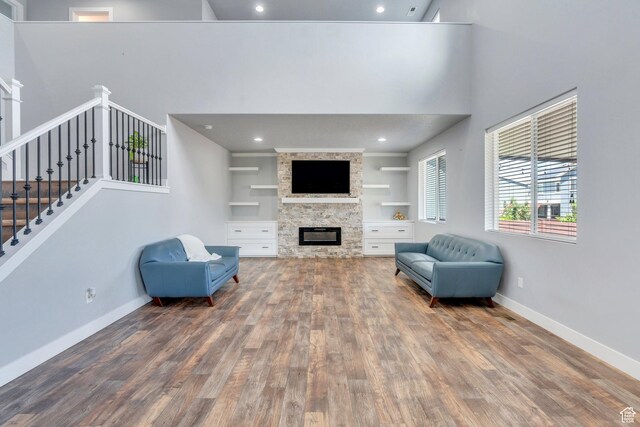 123 E 460 N, Vineyard, UT 84059 - living room featuring wood finished floors, a stone fireplace, a high ceiling, stairs, and built in features