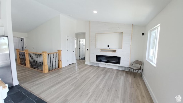 6116 W Graceland Way, West Jordan, UT 84081 - unfurnished living room featuring lofted ceiling, light wood-type flooring, a fireplace, and recessed lighting