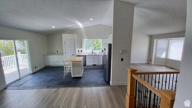 6116 W Graceland Way, West Jordan, UT 84081 - kitchen with lofted ceiling, white cabinetry, a center island, light countertops, and stainless steel appliances