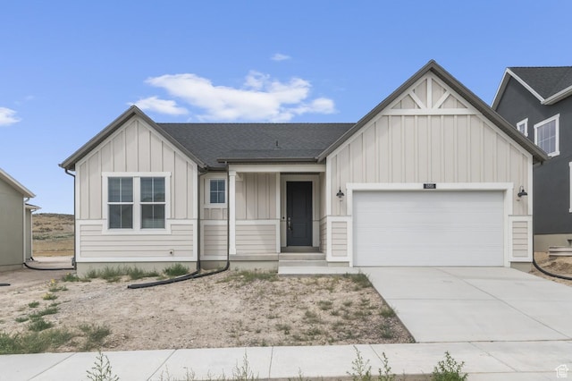 1881 E Moho Mtn, Eagle Mountain, UT 84005 - view of front of home featuring board and batten siding, an attached garage, concrete driveway, and a shingled roof