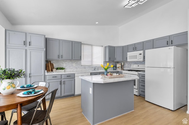 9152 S Crystal Vista Ln, West Jordan, UT 84088 - kitchen with white appliances, gray cabinetry, backsplash, high vaulted ceiling, and light wood-type flooring