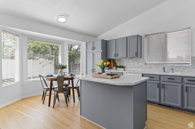 9152 S Crystal Vista Ln, West Jordan, UT 84088 - kitchen with gray cabinetry, tasteful backsplash, light wood-style floors, and vaulted ceiling