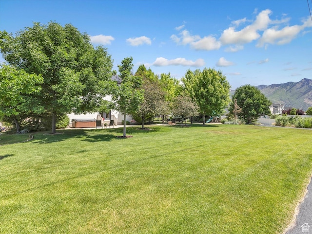 6037 Chamberry Way N, Highland, UT 84003 - view of green lawn with a hot tub and a mountain view