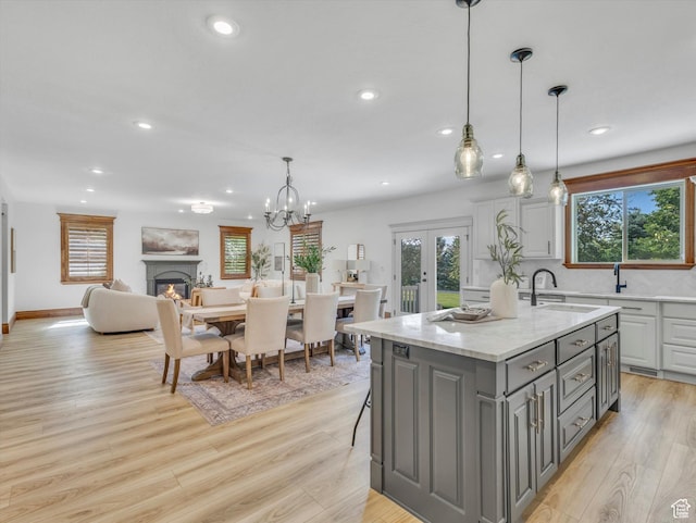 6037 Chamberry Way N, Highland, UT 84003 - kitchen with gray cabinetry, recessed lighting, french doors, an island with sink, and light wood-style floors
