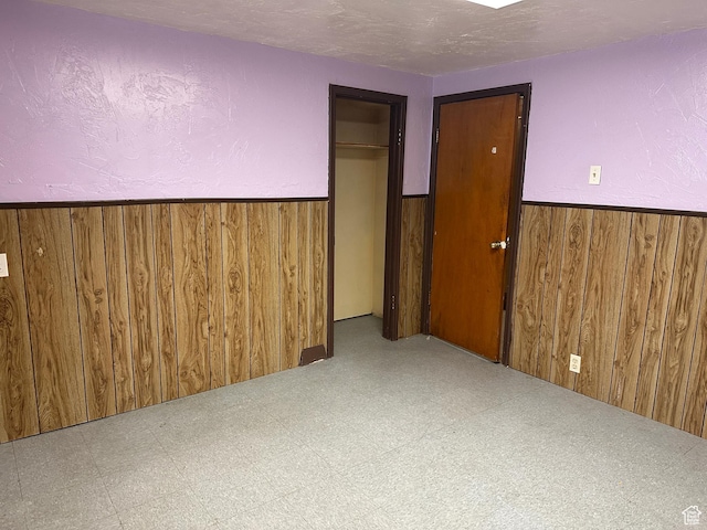 250 E Beryl, South Salt Lake, UT 84115 - unfurnished bedroom featuring wood walls, a wainscoted wall, tile patterned floors, and a closet