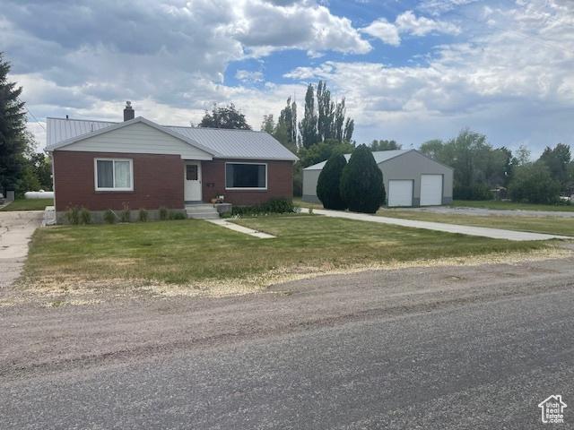 535 W 500 N, Malad City, ID 83252 - view of front of house with a garage, a chimney, a front lawn, an outbuilding, and a metal roof