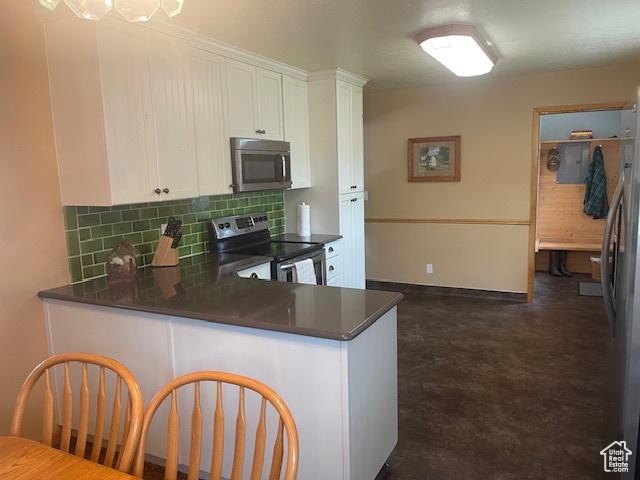 535 W 500 N, Malad City, ID 83252 - kitchen featuring stainless steel appliances, dark countertops, backsplash, and white cabinetry