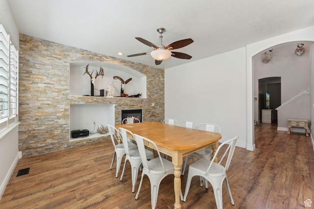 15106 S Heather Stone Cir, Draper, UT 84020 - dining room featuring ceiling fan, arched walkways, a fireplace, wood finished floors, and recessed lighting