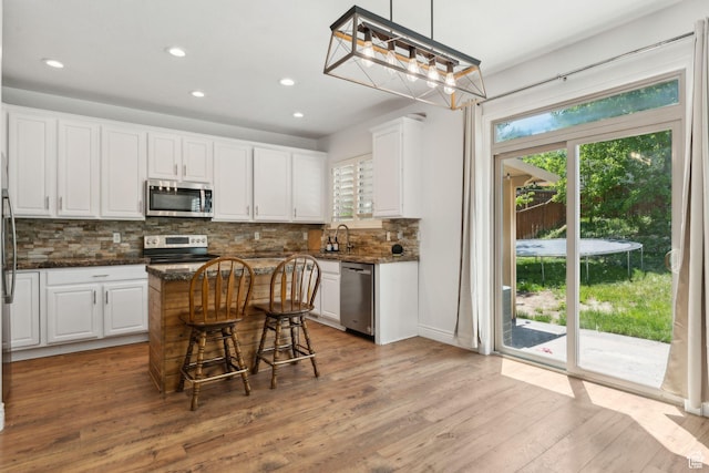 15106 S Heather Stone Cir, Draper, UT 84020 - kitchen with stainless steel appliances, white cabinetry, recessed lighting, tasteful backsplash, and light wood-style flooring