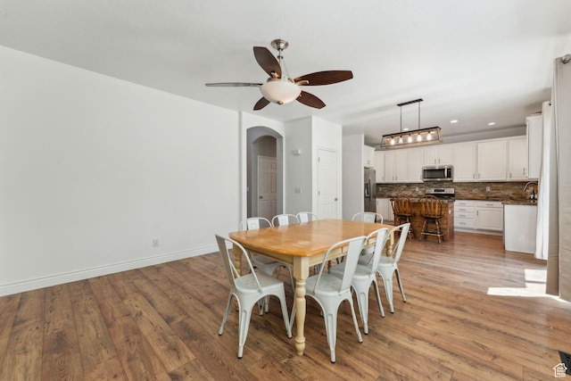 15106 S Heather Stone Cir, Draper, UT 84020 - dining room featuring arched walkways, a ceiling fan, light wood-type flooring, and recessed lighting