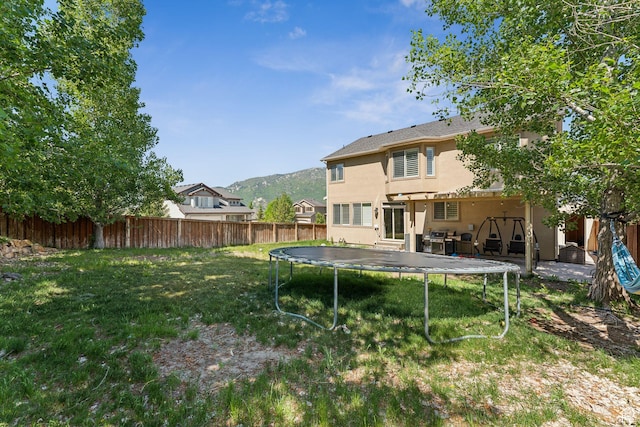 15106 S Heather Stone Cir, Draper, UT 84020 - back of house with a trampoline, stucco siding, a fenced backyard, and a mountain view