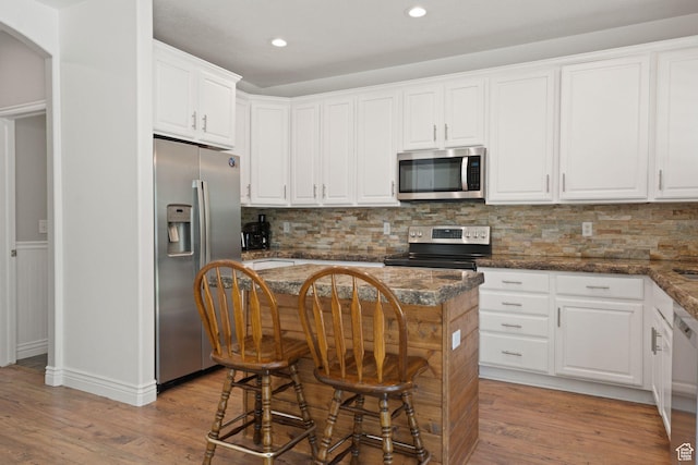 15106 S Heather Stone Cir, Draper, UT 84020 - kitchen featuring stainless steel appliances, white cabinetry, light wood finished floors, backsplash, and recessed lighting