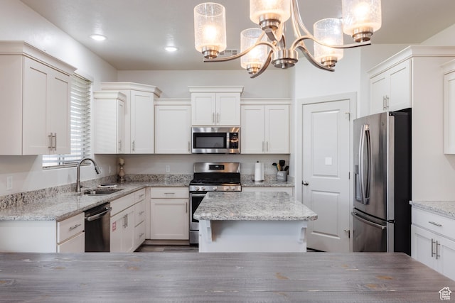 344 N Puerta Dr, Washington, UT 84780 - kitchen with appliances with stainless steel finishes, a chandelier, white cabinetry, a center island, and light stone countertops