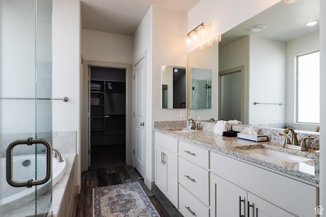 344 N Puerta Dr, Washington, UT 84780 - bathroom with double vanity, wood finished floors, a stall shower, a garden tub, and a spacious closet