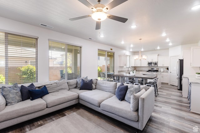 344 N Puerta Dr, Washington, UT 84780 - living room with light wood-style flooring, a ceiling fan, a chandelier, and recessed lighting