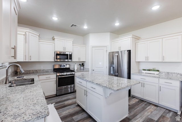 344 N Puerta Dr, Washington, UT 84780 - kitchen featuring stainless steel appliances, white cabinetry, dark wood-type flooring, a center island, and light stone countertops