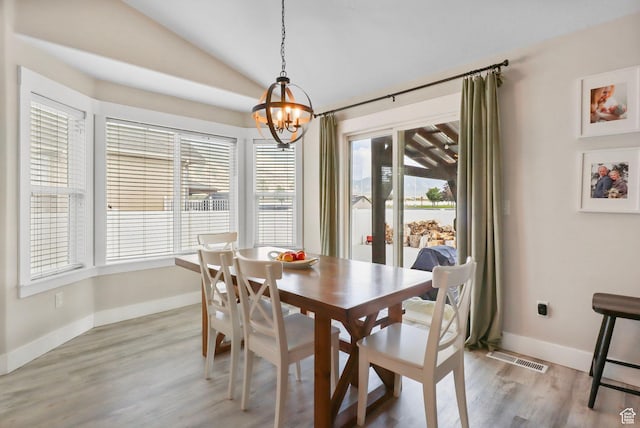 448 Lourdes Ln, Stansbury Park, UT 84074 - dining space featuring a chandelier, vaulted ceiling, and light wood-style flooring