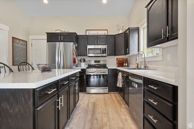 448 Lourdes Ln, Stansbury Park, UT 84074 - kitchen featuring appliances with stainless steel finishes, light wood-type flooring, light countertops, a center island, and recessed lighting