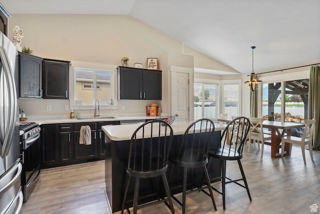 448 Lourdes Ln, Stansbury Park, UT 84074 - kitchen featuring vaulted ceiling, appliances with stainless steel finishes, a breakfast bar, light countertops, and a chandelier