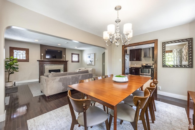 1603 S 1600 E, Salt Lake City, UT 84105 - dining room featuring arched walkways, a tile fireplace, a chandelier, dark wood-style flooring, and recessed lighting