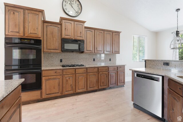 8743 N Franklin Dr E, Eagle Mountain, UT 84005 - kitchen featuring black appliances, vaulted ceiling, backsplash, light wood-style flooring, and light stone counters