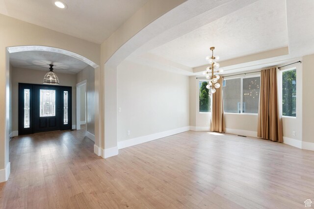 8743 N Franklin Dr E, Eagle Mountain, UT 84005 - entrance foyer featuring a chandelier, light wood finished floors, arched walkways, recessed lighting, and a tray ceiling