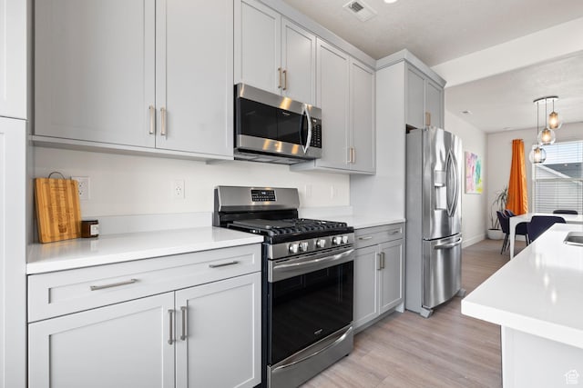11079 S Lake Run Rd, South Jordan, UT 84009 - kitchen featuring appliances with stainless steel finishes, light countertops, light wood-type flooring, and gray cabinets