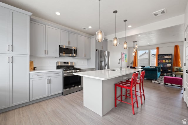 11079 S Lake Run Rd, South Jordan, UT 84009 - kitchen with stainless steel appliances, light wood-type flooring, a breakfast bar, light countertops, and recessed lighting