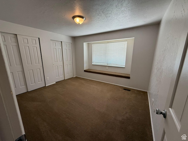 5509 S 2150 W, Roy, UT 84067 - unfurnished bedroom featuring two closets, carpet floors, and a textured ceiling