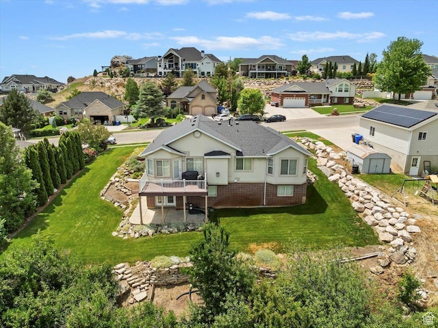 3634 N 225 E, North Ogden, UT 84414 - rear view of property with a residential view, a storage unit, brick siding, a lawn, and a wooden deck