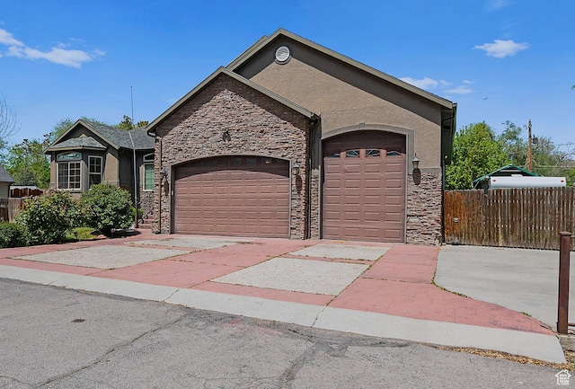 3903 S 3200 W, West Valley City, UT 84119 - view of front of house featuring stone siding, an attached garage, stucco siding, and driveway