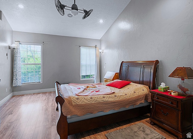 3903 S 3200 W, West Valley City, UT 84119 - bedroom with vaulted ceiling, a textured ceiling, multiple windows, wood finished floors, and a textured wall
