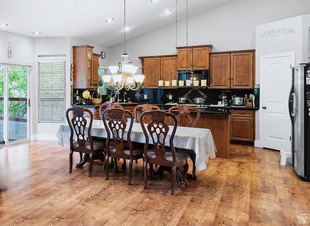3903 S 3200 W, West Valley City, UT 84119 - kitchen featuring dark countertops, brown cabinets, tasteful backsplash, a chandelier, and light wood-style floors